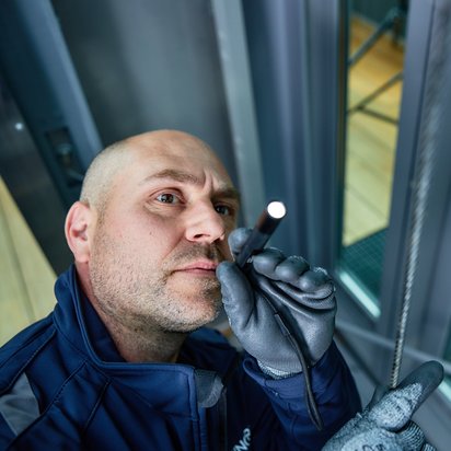 Inspecteur voert een technische inspectie uit in een liftinstallatie.