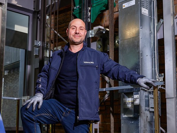 Inspecteur voert een technische inspectie uit in een liftinstallatie.