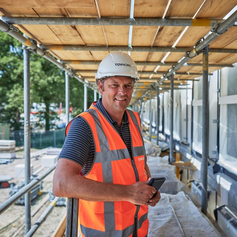 TÜV NORD medewerker staat klaar voor al je vragen. TÜV NORD medewerkers in een bouwomgeving