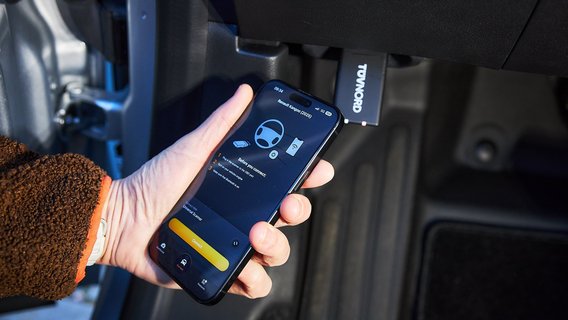 Telefoon in de hand, zichtbaar OBD systeem